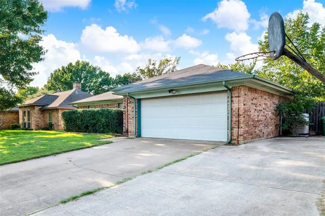 a front view of a house with a garden and garage