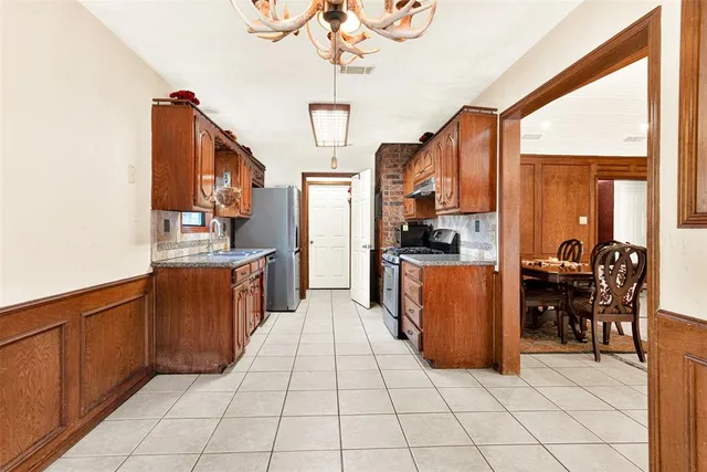 a kitchen with stainless steel appliances a refrigerator and wooden cabinets