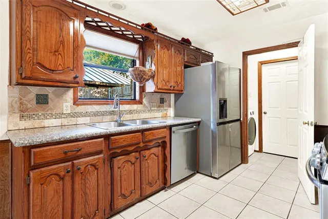 a kitchen with stainless steel appliances granite countertop a refrigerator and a sink