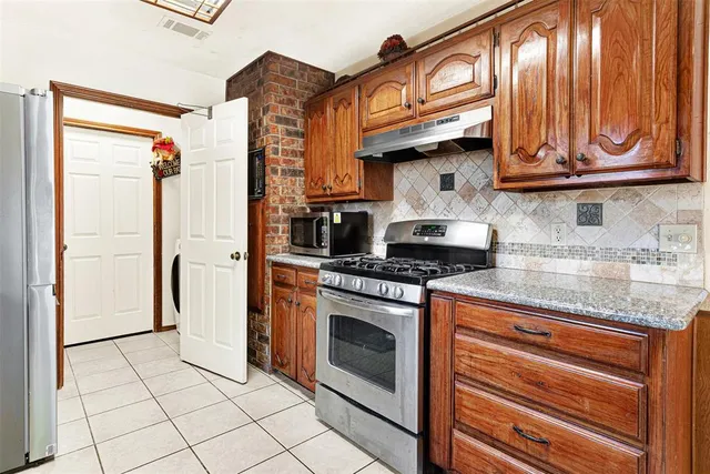 a kitchen with stainless steel appliances granite countertop a stove a washer and dryer