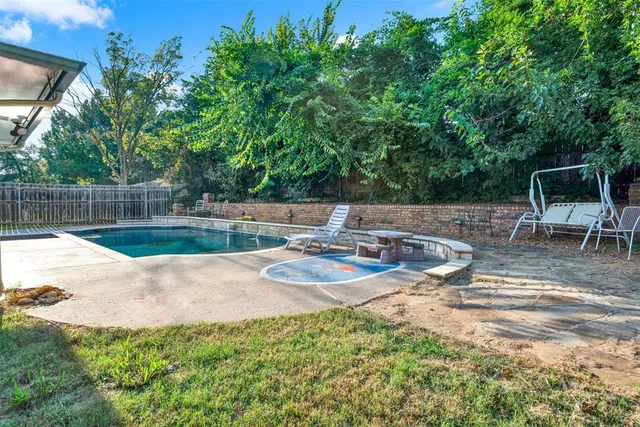 a view of a backyard with swimming pool