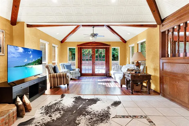 a living room with furniture large window and flat screen tv