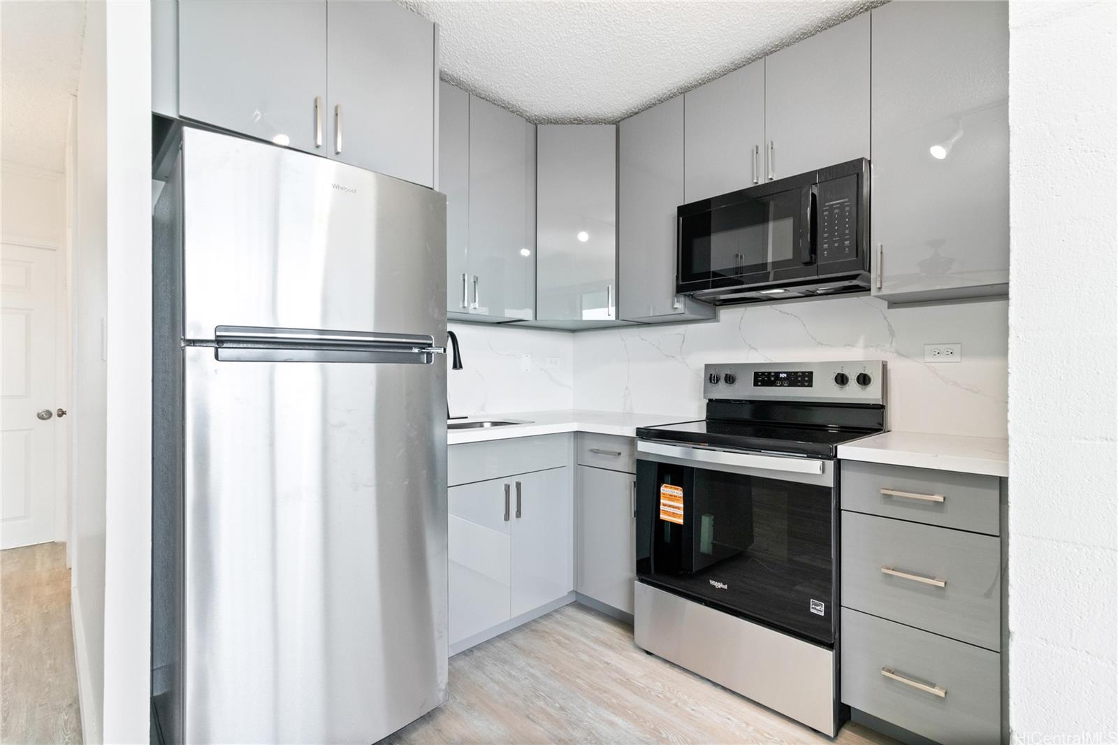 94-249 Waikele Road, Unit A307 Waipahu, HI 96797 - Photo 4 of 20 a kitchen with stainless steel appliances white cabinets and a refrigerator