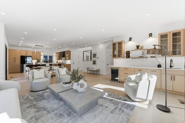 a living room with furniture and a view of kitchen