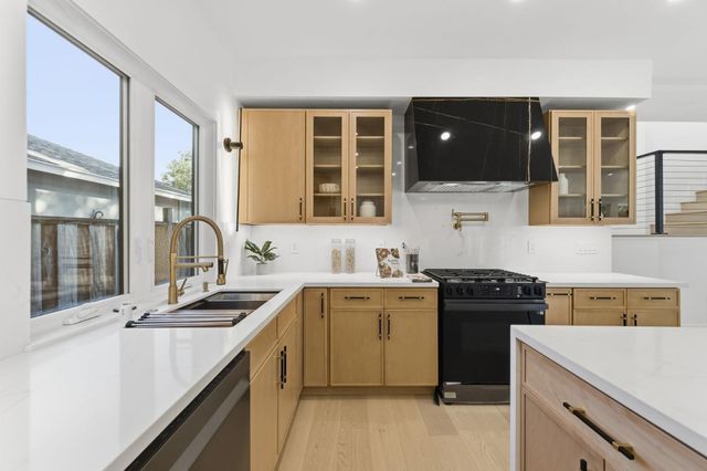 a kitchen that has a sink and a stove in it
