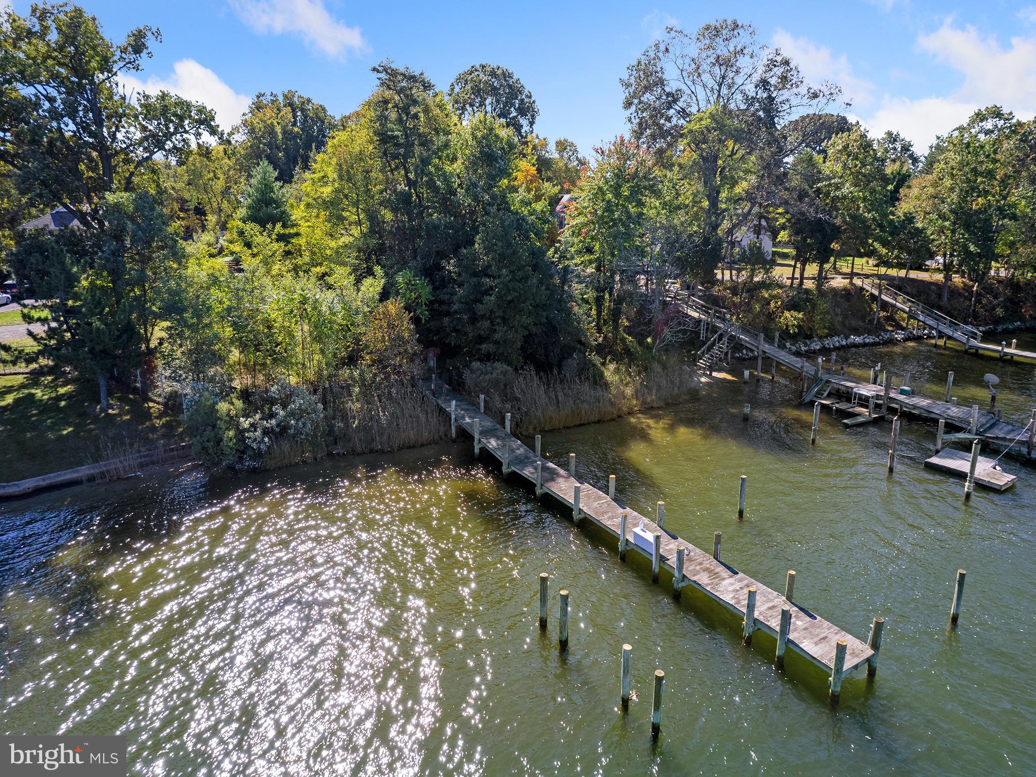 13374 Rousby Hall Road Lusby, MD 20657 - Photo 4 of 14 a view of a lake with a yard and mountain
