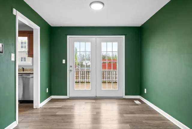 an empty room with wooden floor and a window