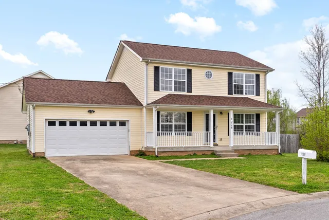 a front view of a house with a garden and yard