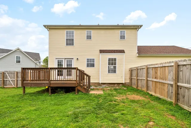 a view of a house with backyard and fence