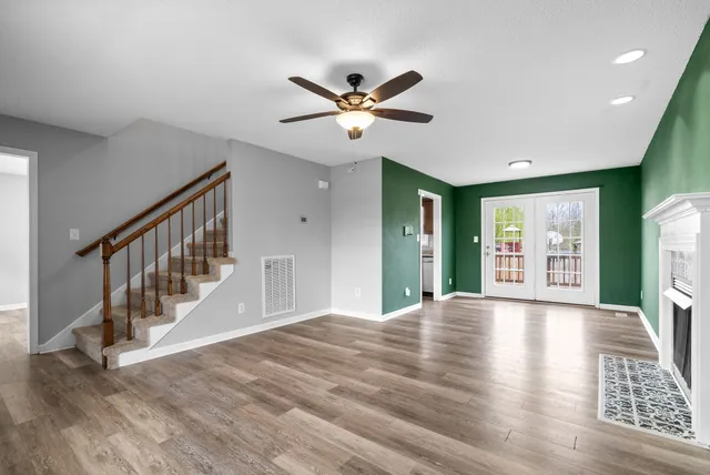 a view of an empty room with window and wooden floor