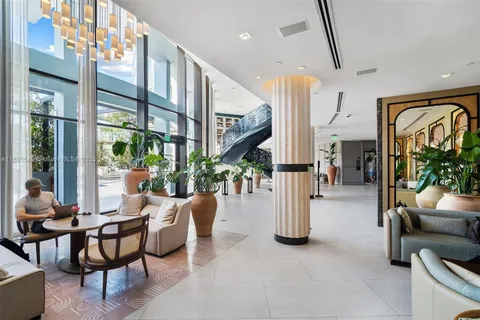 a dining room with furniture and a floor to ceiling window