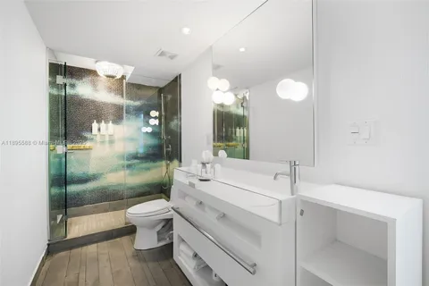 a bathroom with a bathtub shower sink mirror and toilet