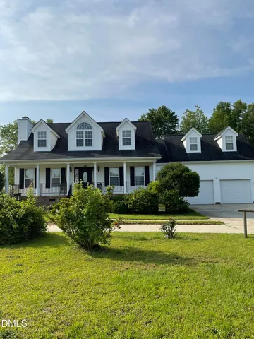 a front view of a house with a yard and potted plants