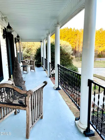 a view of a balcony with furniture and floor to ceiling window