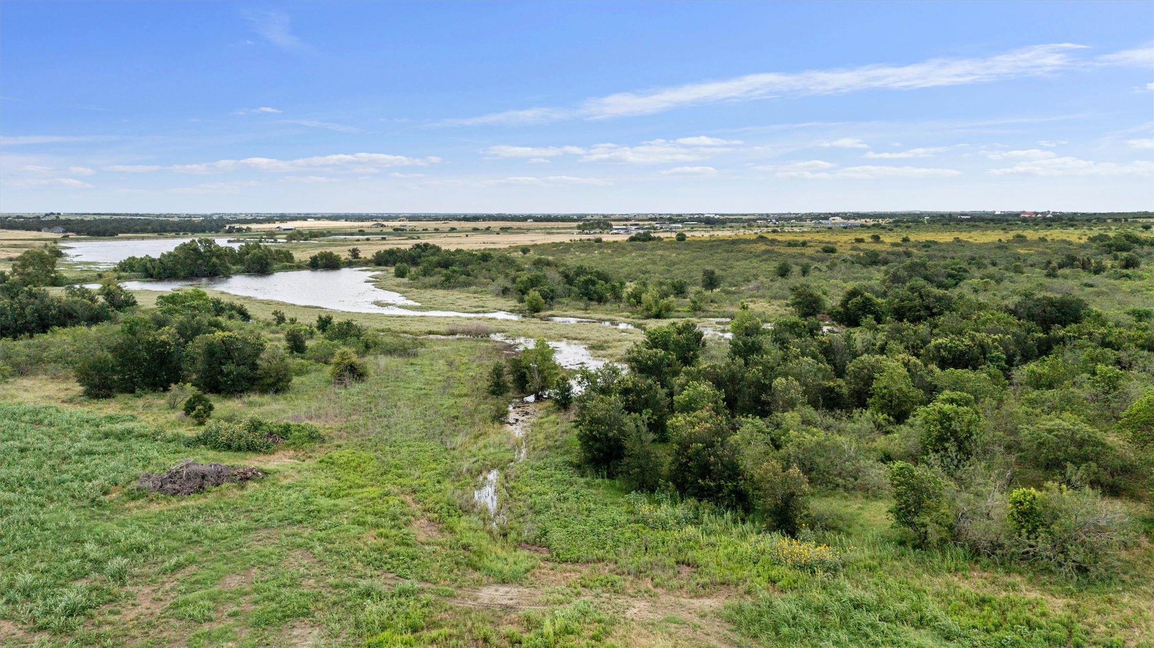 3315 County Road 463 Elgin, TX 78621 - Photo 12 of 32 Vast natural landscapes offering a serene view of a tranquil lake amidst lush greenery.