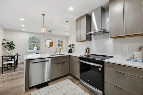a kitchen with stainless steel appliances granite countertop a sink stove and cabinets