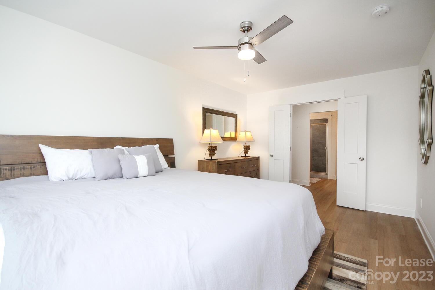1084 Startown Road Lincolnton, NC 28092 - Photo 28 of 48 a bedroom with a large bed and a chandelier