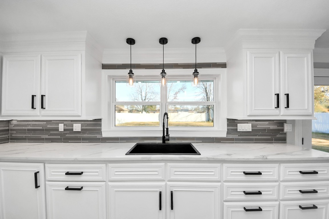 16121 Palm Street Channelview, TX 77530 - Photo 11 of 26 a kitchen with kitchen island a sink a window and cabinets