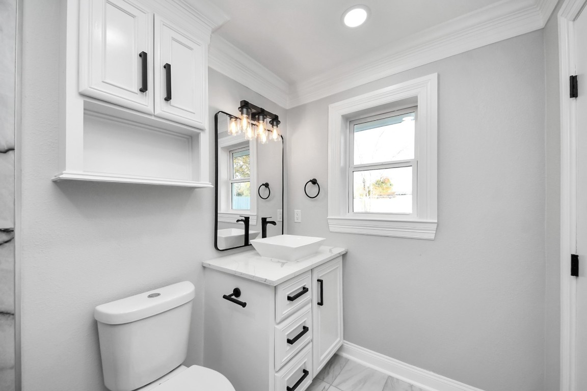 16121 Palm Street Channelview, TX 77530 - Photo 24 of 26 a bathroom with a toilet sink and mirror