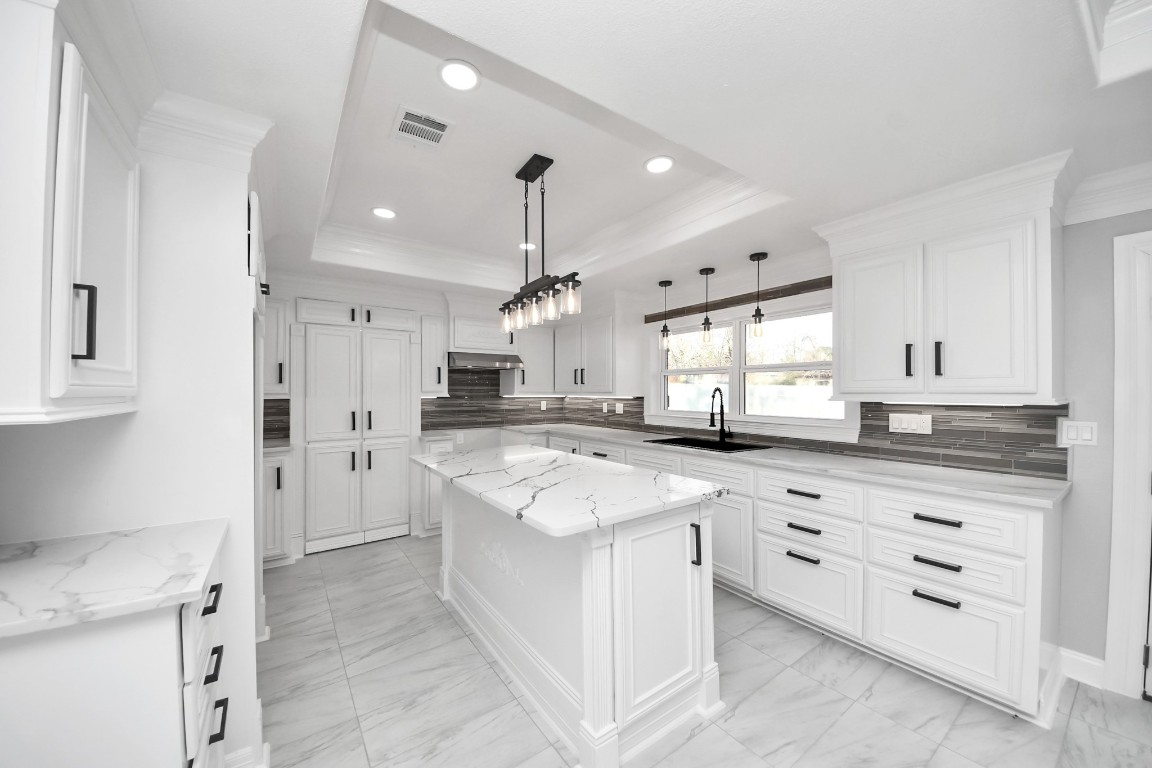 16121 Palm Street Channelview, TX 77530 - Photo 10 of 26 a large kitchen with granite countertop a sink stove a refrigerator and white cabinets