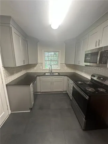 a kitchen with a sink stove and cabinets