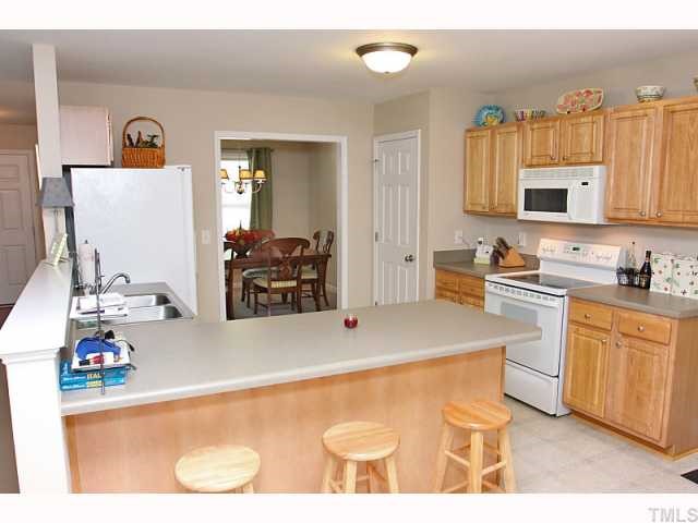 2708 Rustic Brick Road Raleigh, NC 27603 - Photo 3 of 12 a kitchen with stainless steel appliances a stove a sink and a refrigerator