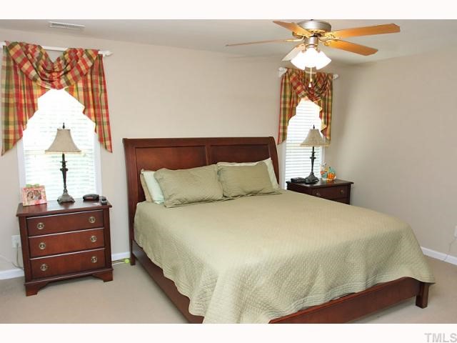 2708 Rustic Brick Road Raleigh, NC 27603 - Photo 7 of 12 a bedroom with a bed and a chandelier