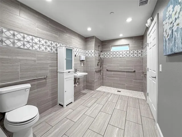 a bathroom with a sink a toilet and shower