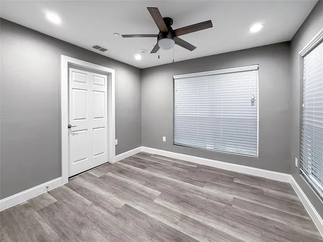 a view of an empty room with a window and a ceiling fan