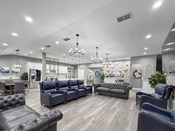 a living room with furniture kitchen view and a chandelier