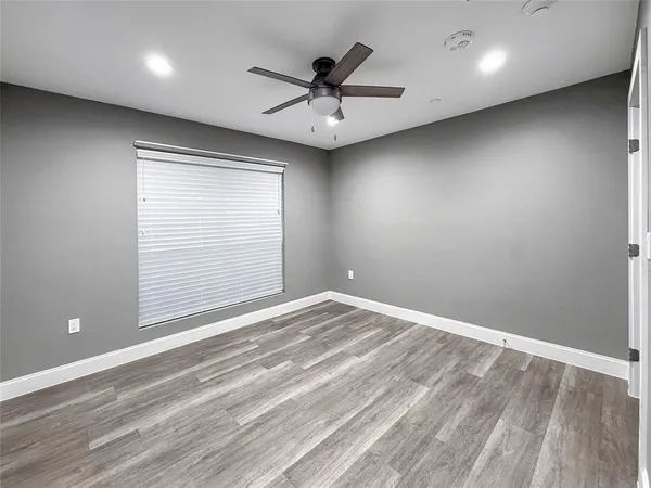 an empty room with a window and a ceiling fan