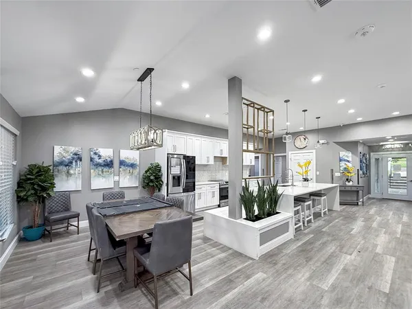a living room with furniture a wooden floor and kitchen view