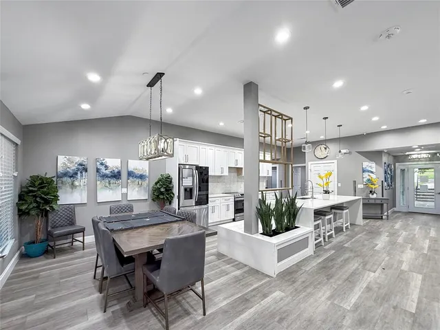 a living room with furniture a wooden floor and kitchen view