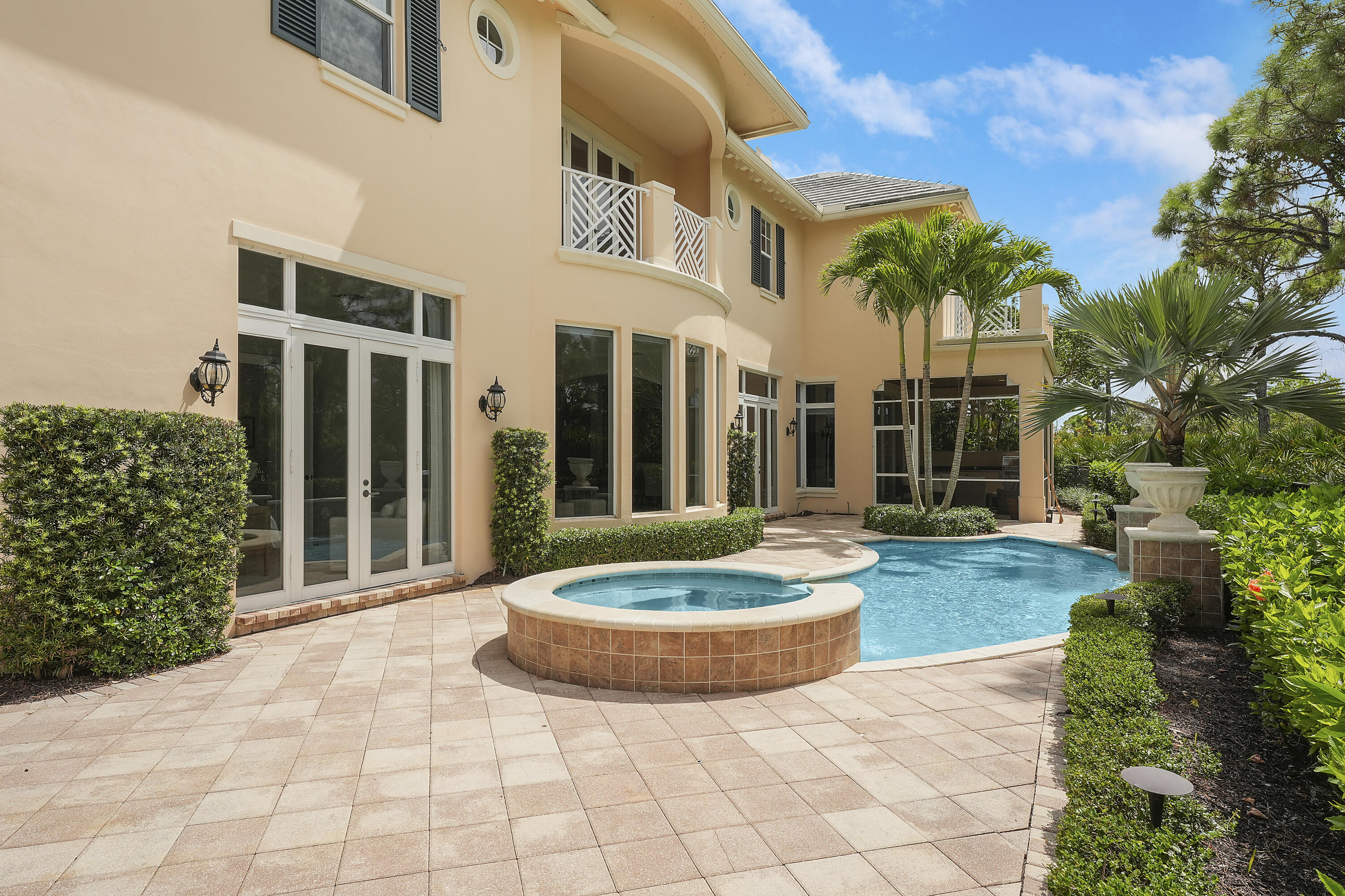 140 Tulip Tree Court Jupiter, FL 33458 - Photo 25 of 80 a view of a white house with a yard and potted plants