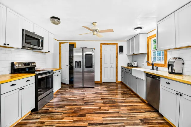 a kitchen with stainless steel appliances granite countertop a refrigerator a stove top oven a sink and dishwasher