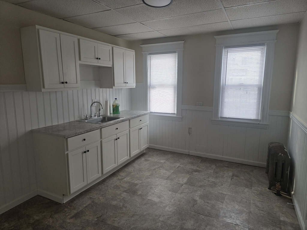 100 Albemarle Street, Unit 1 Springfield, MA 01109 - Photo 2 of 11 a kitchen with white cabinets and window