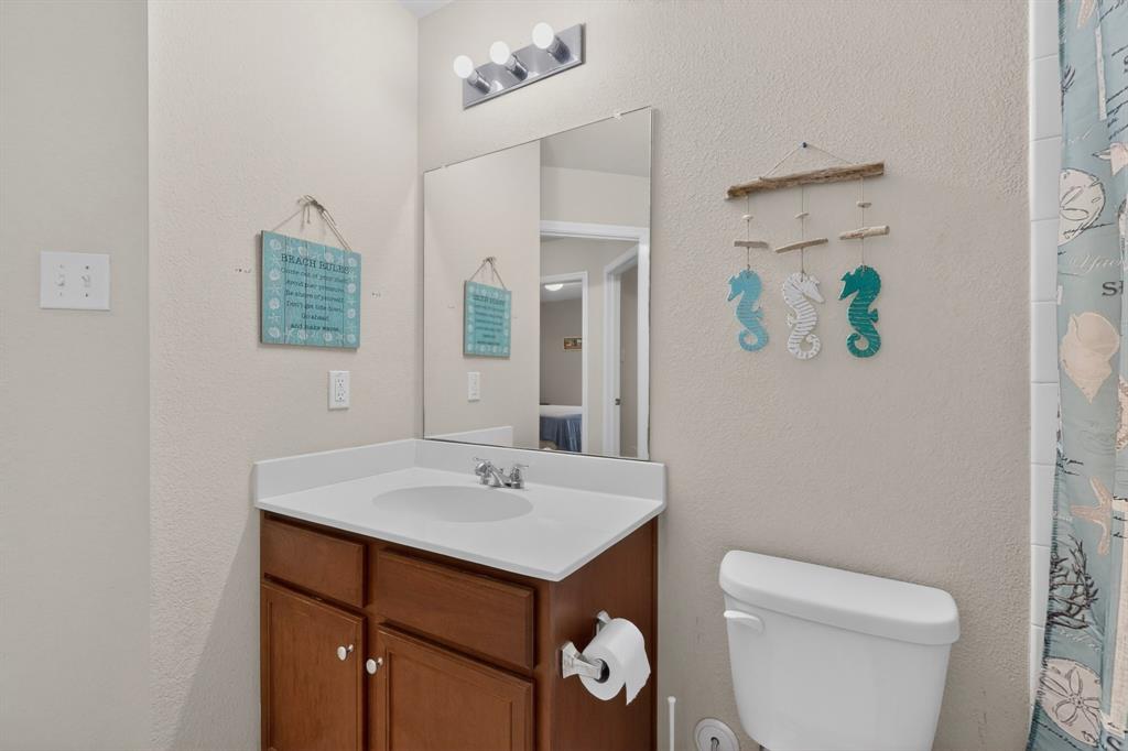 1409 Slate Street Princeton, TX 75407 - Photo 16 of 36 Vanity with wood-finish cabinetry, integrated sink, and white countertop