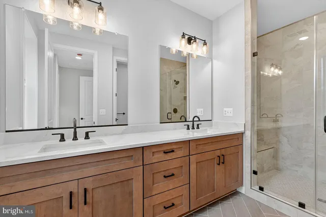a bathroom with double vanity sinks and a shower