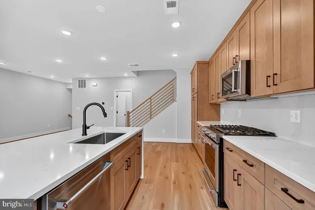 a kitchen with stainless steel appliances a sink stove and cabinets