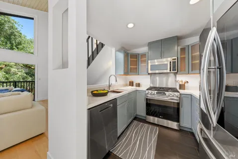 a kitchen with stainless steel appliances granite countertop a refrigerator a stove and a sink