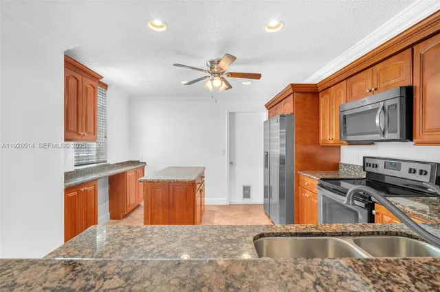 a kitchen with stainless steel appliances granite countertop a sink a stove and a refrigerator