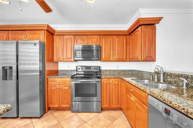 a kitchen with stainless steel appliances granite countertop a sink stove and refrigerator