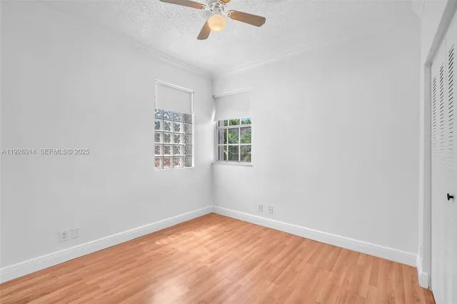 an empty room with a window and wooden floor