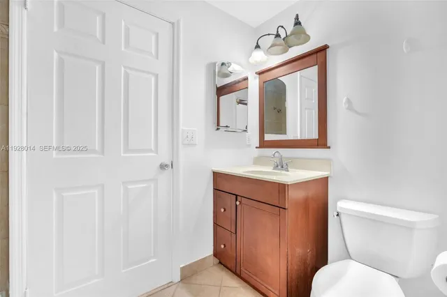 a bathroom with a toilet a sink a mirror a vanity and window