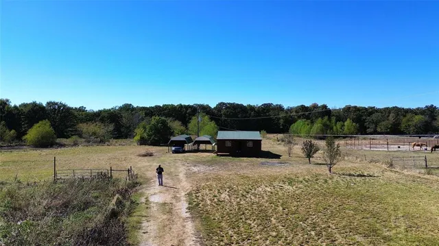 a view of a backyard with lawn chairs wooden floor and fence