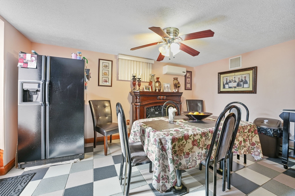 493 Peckham Street Fall River, MA 02721 - Photo 15 of 38 a dining room with furniture a flat screen tv and a refrigerator