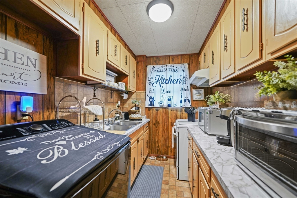 493 Peckham Street Fall River, MA 02721 - Photo 28 of 38 a kitchen with stainless steel appliances granite countertop a stove a sink dishwasher and cabinets with wooden floor