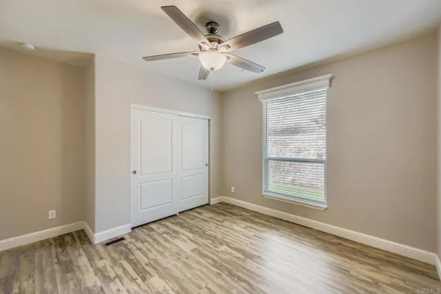 a bathroom with a granite countertop sink toilet and large mirror