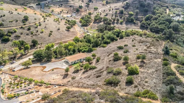 an aerial view of a house with a yard and wooden fence