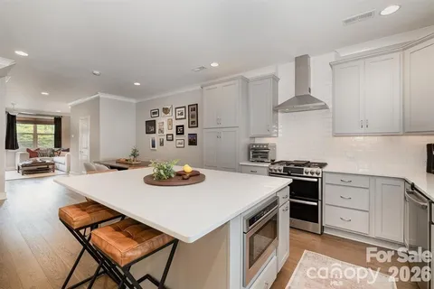 a kitchen with a stove a table and chairs in it